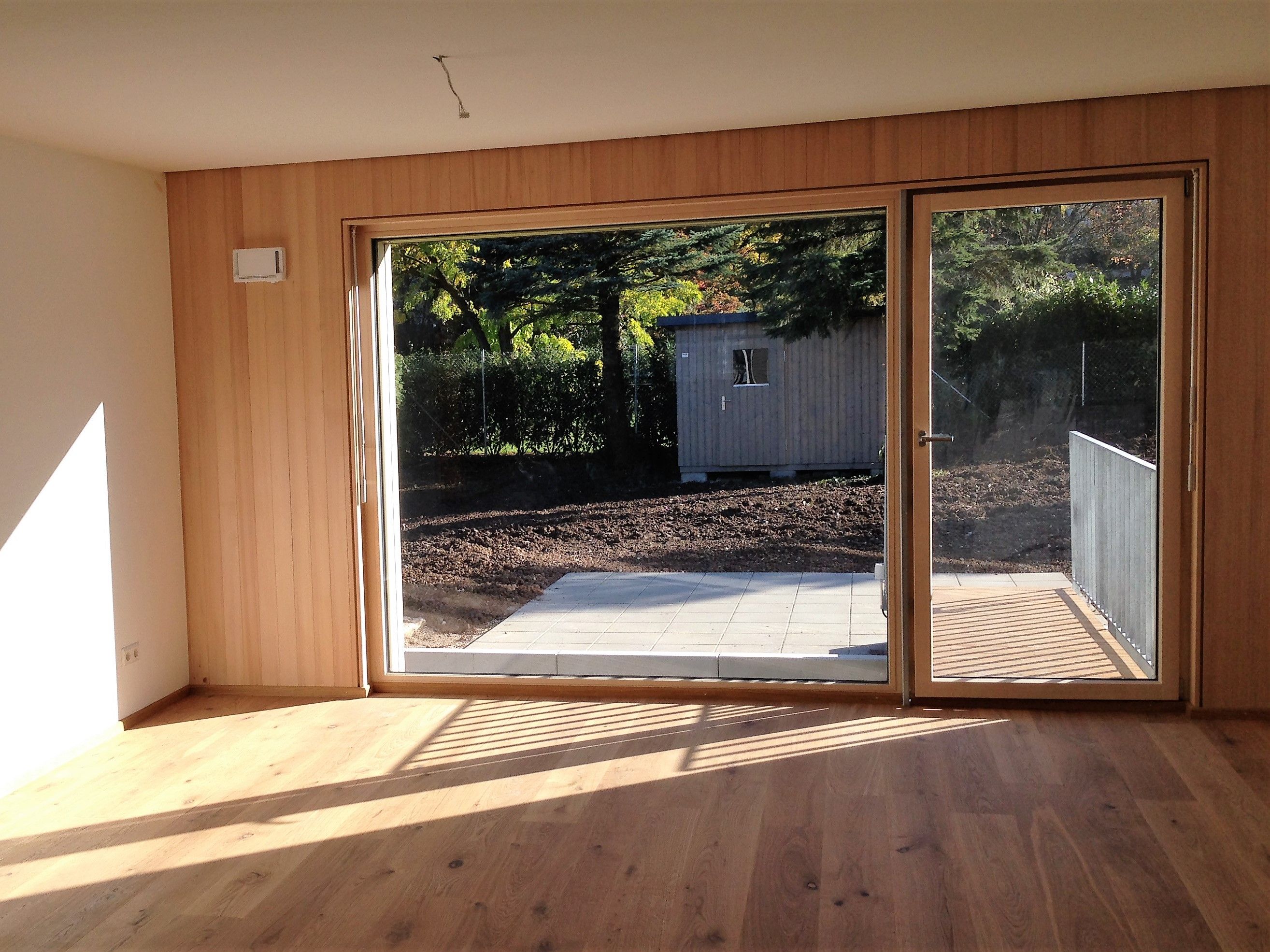 Glasfront mit Holzauskleidung und Glastür